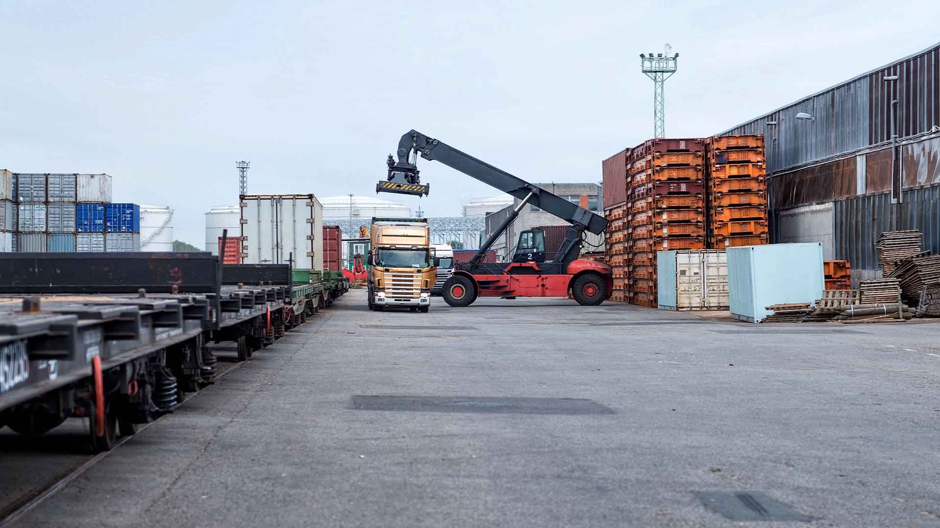 Photo at a port showing a container going from boat to truck during transloading process