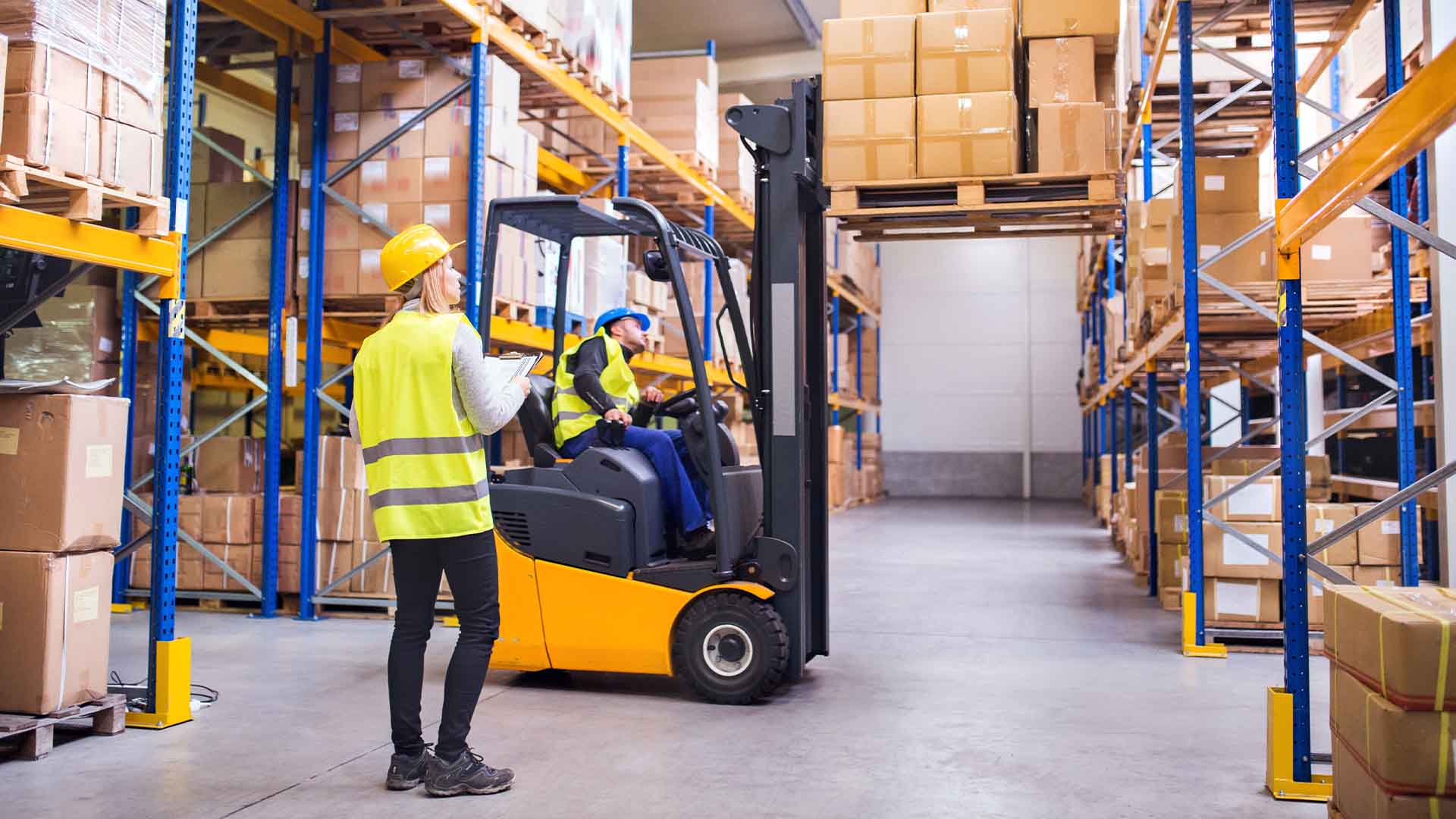 Photo of employees working in a warehouse with a forklift